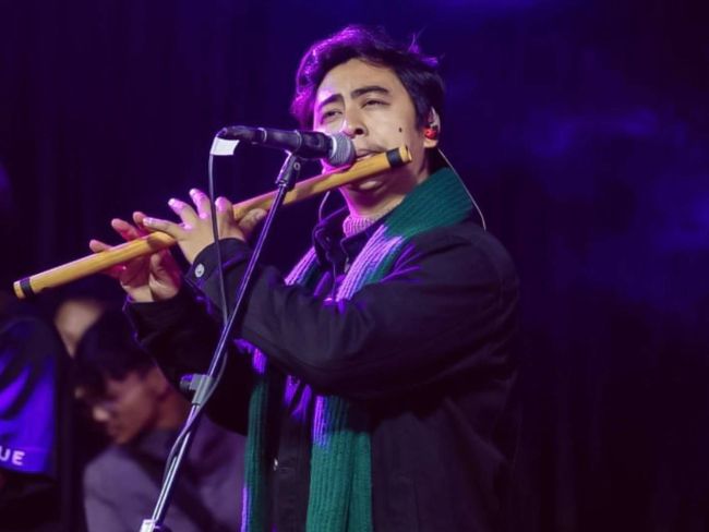 Aman Mali Playing Flute on Stage